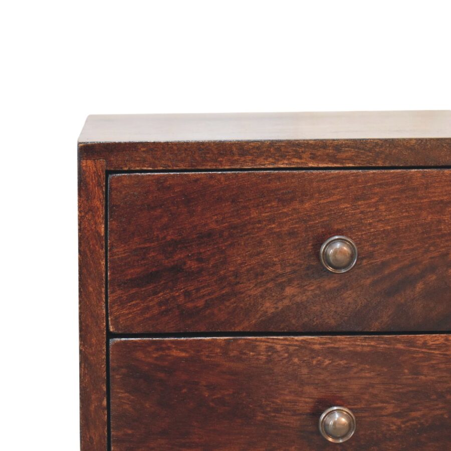 Wooden chest of drawers with metal knobs.